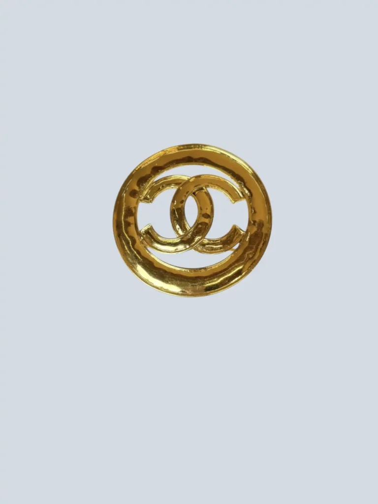 Gold-plated CC logo brooch.