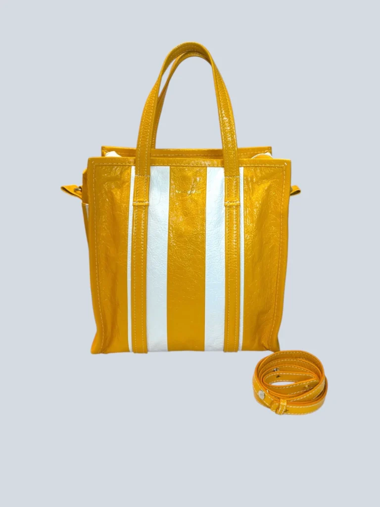 Balenciaga yellow shopper bag with white stripes, front view.