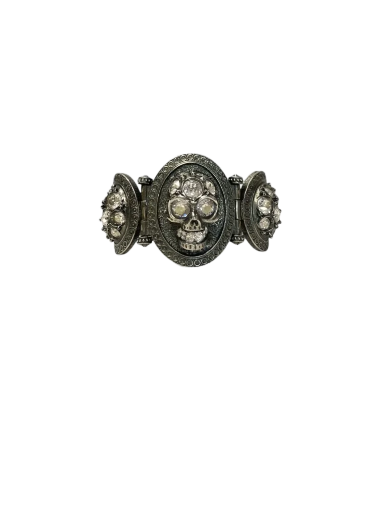 Bracciale in metallo lavorato con teschi e strass.