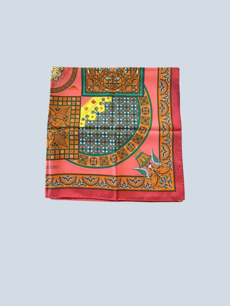 Foulard Hermès piegato con dettagli rosa e arancioni.