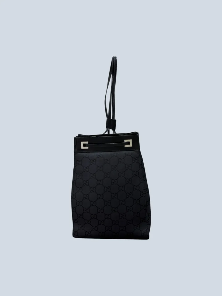 Gucci one-shoulder backpack in black canvas with monogram on the front.