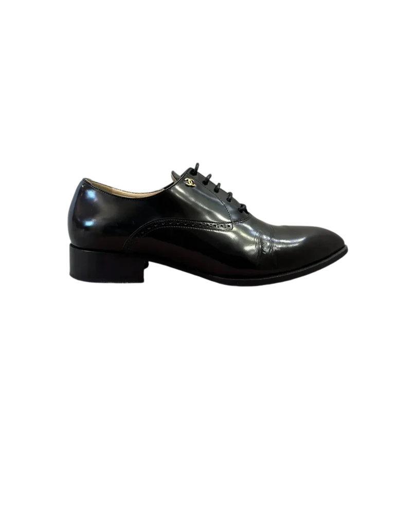 Scarpa stringata Chanel in pelle nera vista di lato.